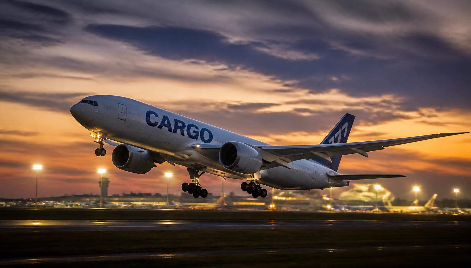 Cargo freighter aircraft taking off at dusk